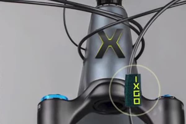 X als Batch am Steuerrohr und kleine Tags mit dem Markennamen zur Kennzeichnung von E-Bikes der Marke IXGO